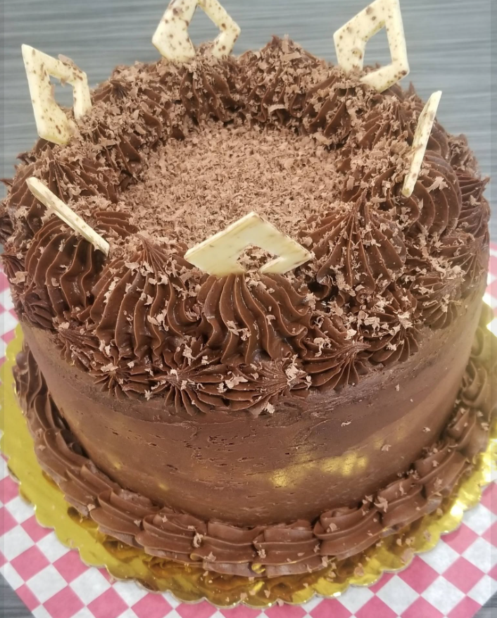 Chocolate layer cake with chocolate shavings and white chocolate accents